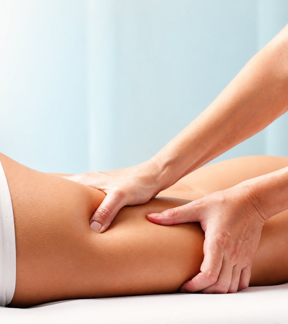 Fisioterapeuta aplicando terapia manual na perna de uma paciente durante sessão na Fisio In